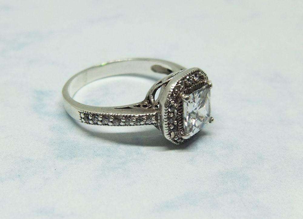 AN ENGAGEMENT STYLE SOLID STERLING SILVER RING SET WITH FACETED CZ STONES