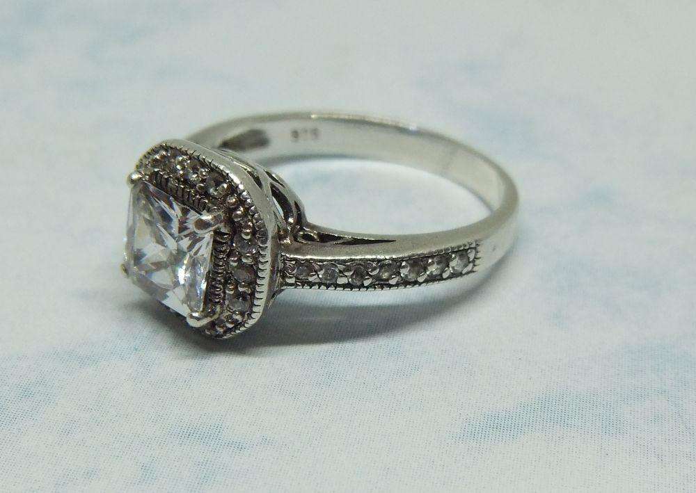 AN ENGAGEMENT STYLE SOLID STERLING SILVER RING SET WITH FACETED CZ STONES