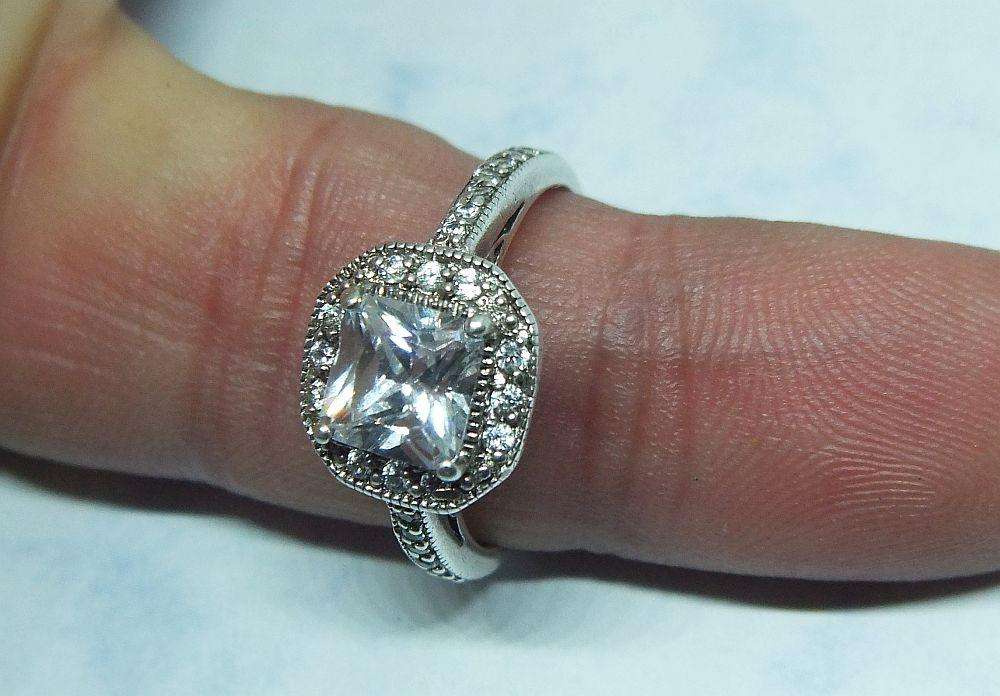 AN ENGAGEMENT STYLE SOLID STERLING SILVER RING SET WITH FACETED CZ STONES