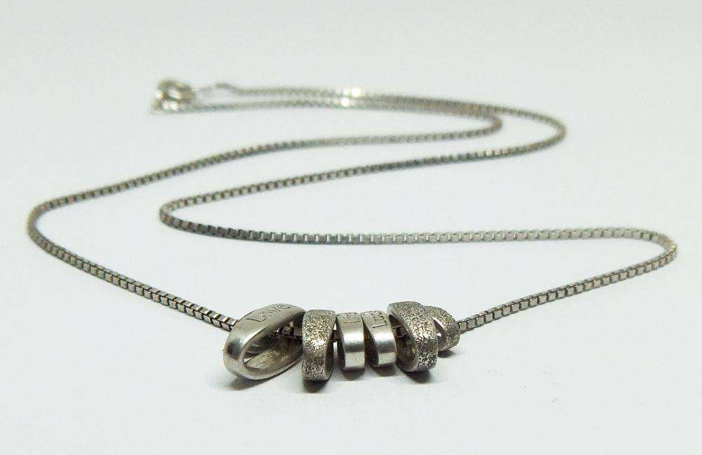A quality sterling silver necklace with unique "Love, Life, Luck" theme pendants in great condition