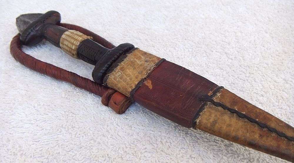 A RARE ANTIQUE DAGGER OF THE NORTH AFRICAN TUAREG TRIBE COVERED WITH GENUINE SNAKESKIN AND LEATHER