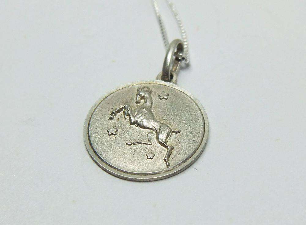 A vintage sterling silver Capricorn Zodiac sign pendant with a sterling silver necklace