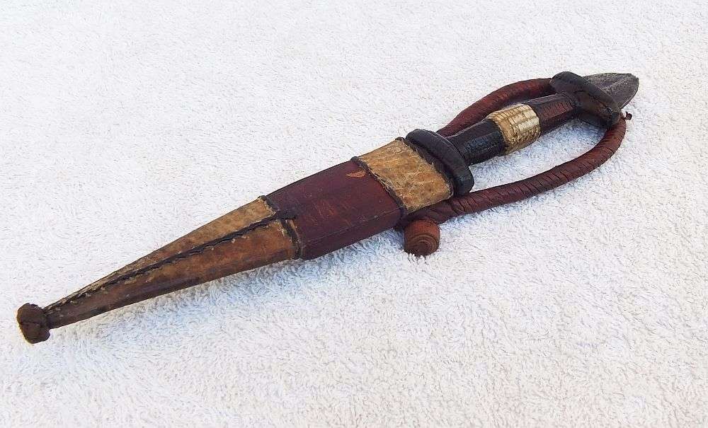 A RARE ANTIQUE DAGGER OF THE NORTH AFRICAN TUAREG TRIBE COVERED WITH GENUINE SNAKESKIN AND LEATHER