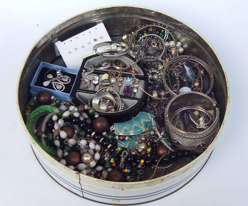 A rusty old tin filled with loads of usable jewelry and spare parts