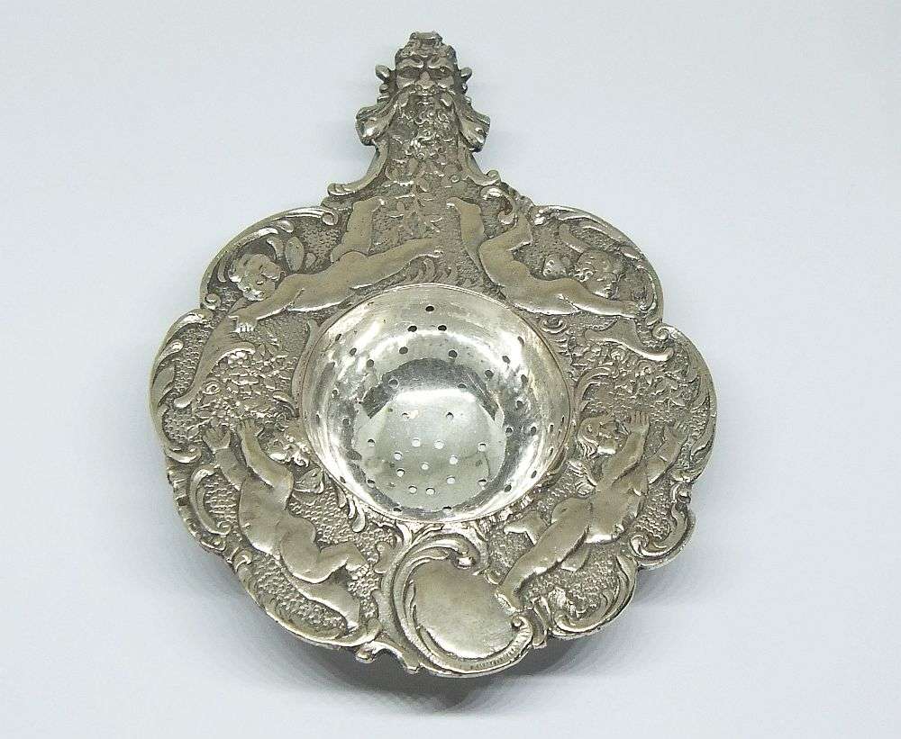 WOW !! A BEAUTIFUL ANTIQUE TEA STRAINER DECORATED WITH CHERUBS STAMPED WITH UNKNOWN MARKINGS