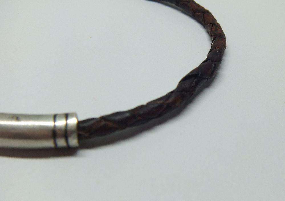 AN UNUSUAL VINTAGE LEATHER BRACELET WITH STERLING SILVER CLASP AND HIGH GRADE SILVER CENTREPIECE