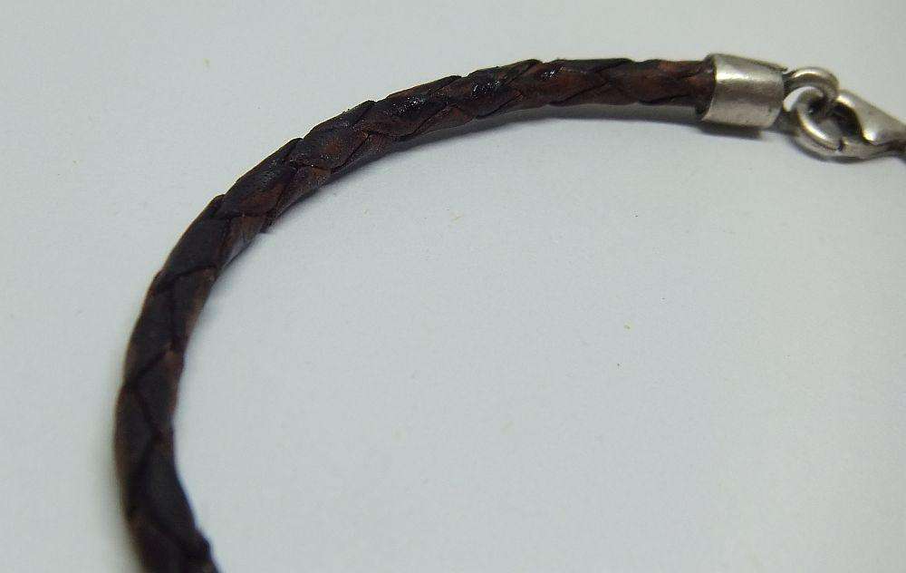 AN UNUSUAL VINTAGE LEATHER BRACELET WITH STERLING SILVER CLASP AND HIGH GRADE SILVER CENTREPIECE