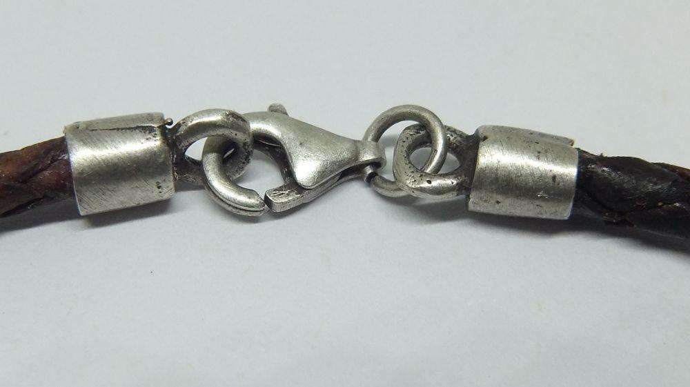 AN UNUSUAL VINTAGE LEATHER BRACELET WITH STERLING SILVER CLASP AND HIGH GRADE SILVER CENTREPIECE