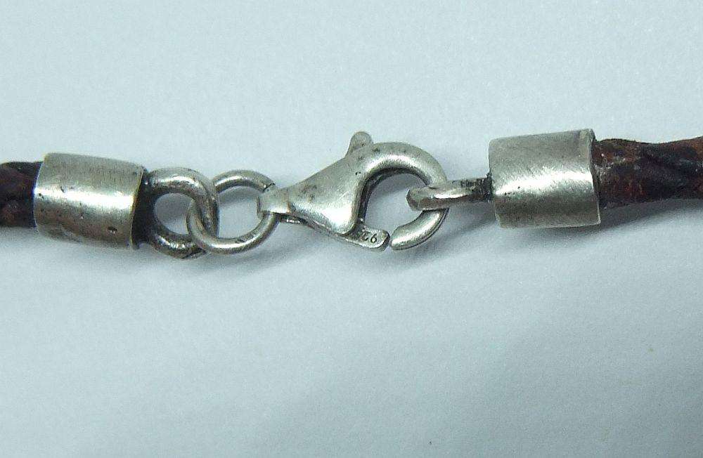 AN UNUSUAL VINTAGE LEATHER BRACELET WITH STERLING SILVER CLASP AND HIGH GRADE SILVER CENTREPIECE