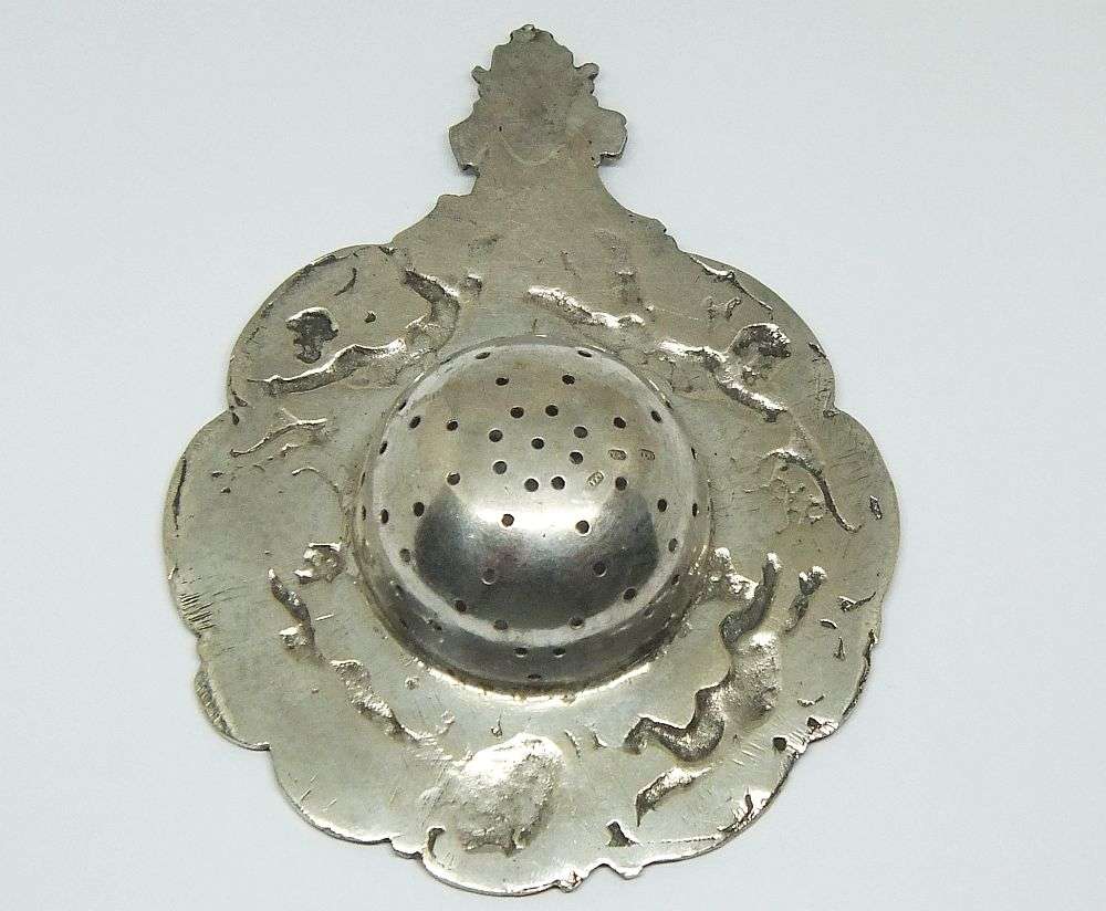 WOW !! A BEAUTIFUL ANTIQUE TEA STRAINER DECORATED WITH CHERUBS STAMPED WITH UNKNOWN MARKINGS