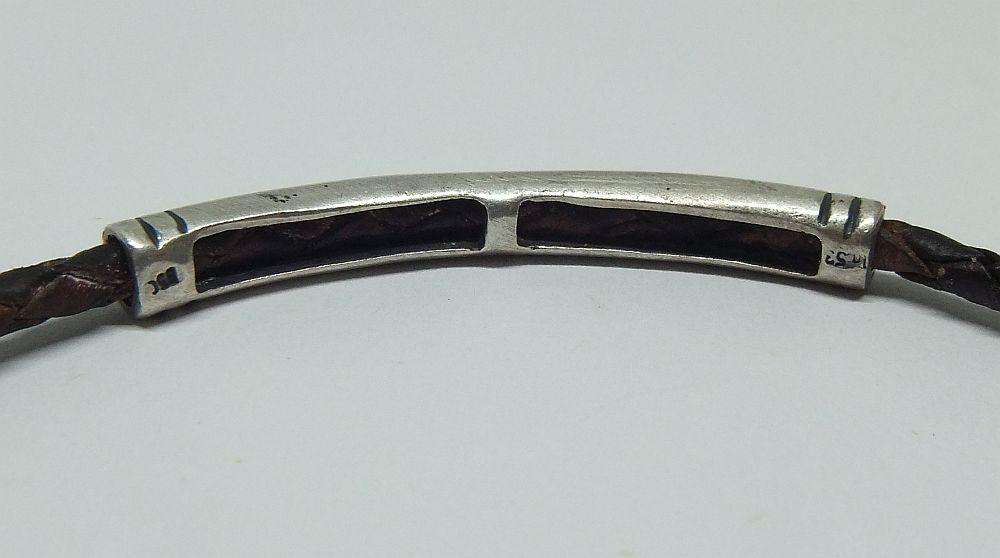 AN UNUSUAL VINTAGE LEATHER BRACELET WITH STERLING SILVER CLASP AND HIGH GRADE SILVER CENTREPIECE