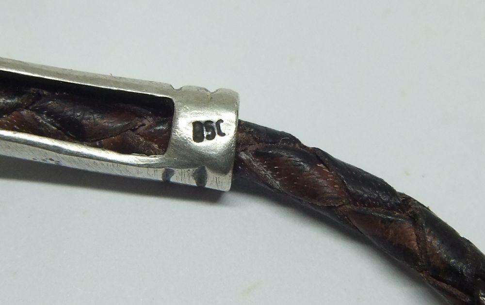 AN UNUSUAL VINTAGE LEATHER BRACELET WITH STERLING SILVER CLASP AND HIGH GRADE SILVER CENTREPIECE