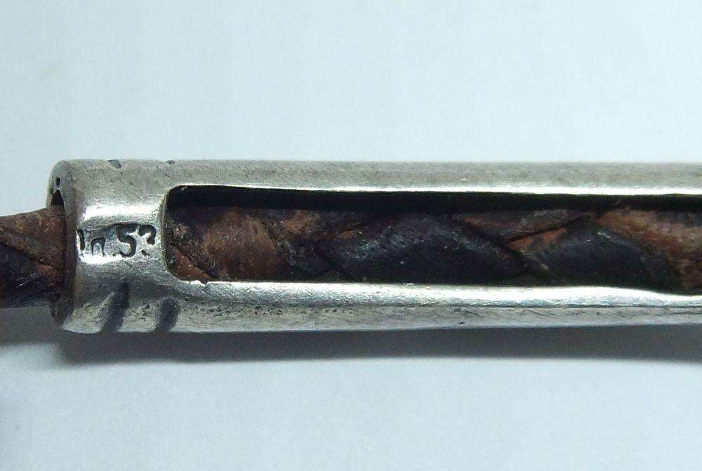 AN UNUSUAL VINTAGE LEATHER BRACELET WITH STERLING SILVER CLASP AND HIGH GRADE SILVER CENTREPIECE