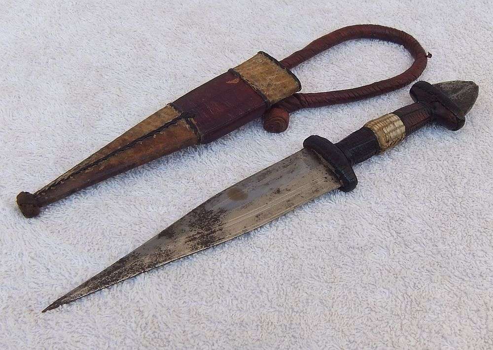 A RARE ANTIQUE DAGGER OF THE NORTH AFRICAN TUAREG TRIBE COVERED WITH GENUINE SNAKESKIN AND LEATHER
