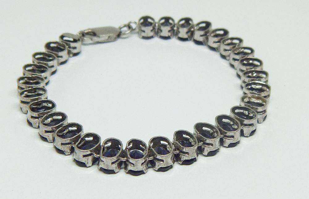A gorgeous sterling silver bracelet with 28 faceted dark blue insets