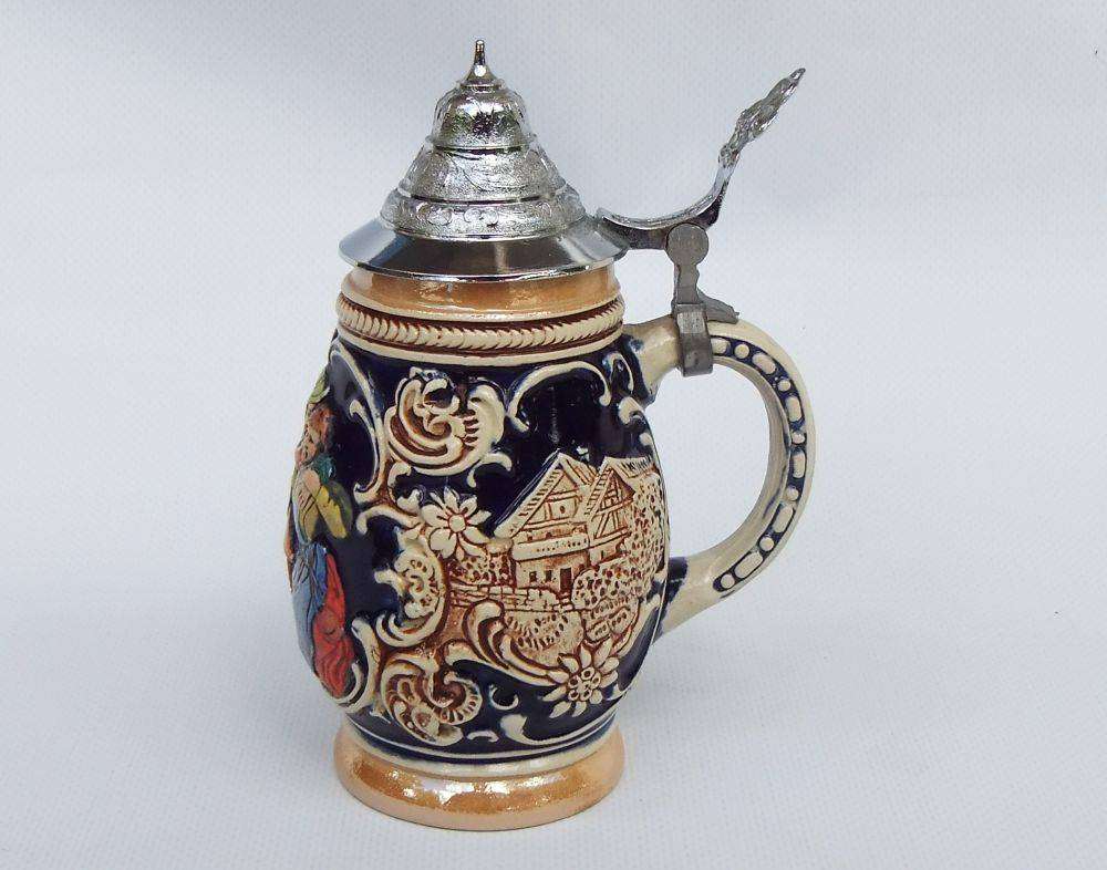 A fabulous vintage German beer stein with hinged metal lid and great detail