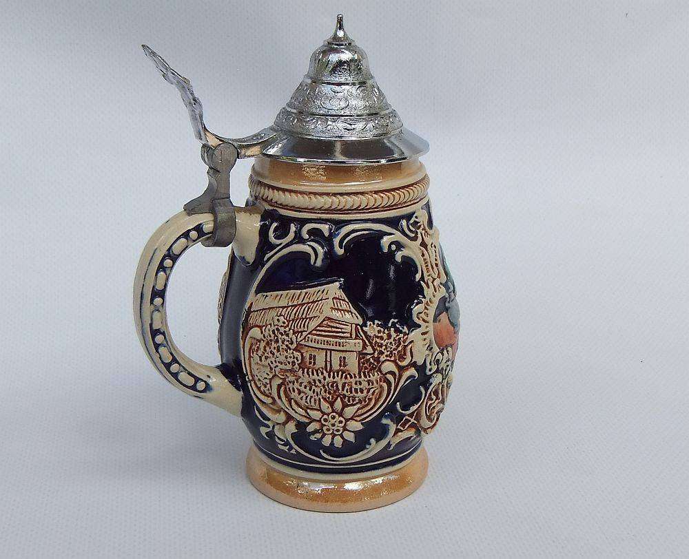 A fabulous vintage German beer stein with hinged metal lid and great detail