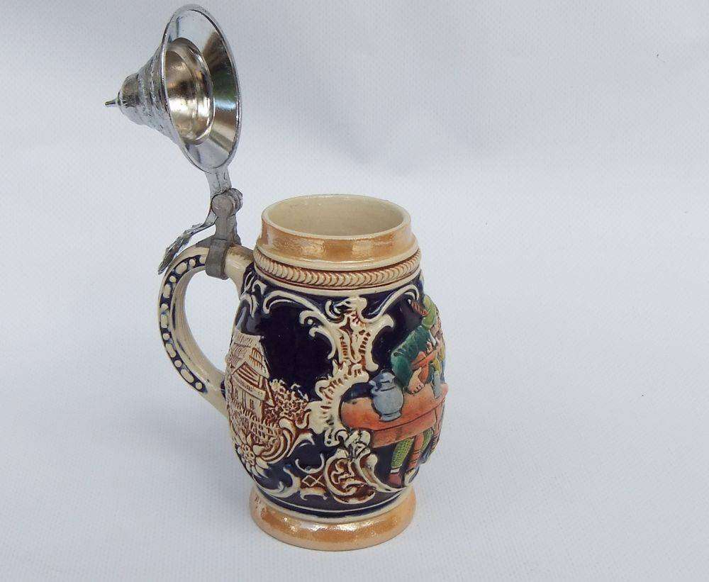 A fabulous vintage German beer stein with hinged metal lid and great detail
