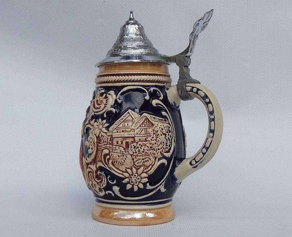 A fabulous vintage German beer stein with hinged metal lid and great detail