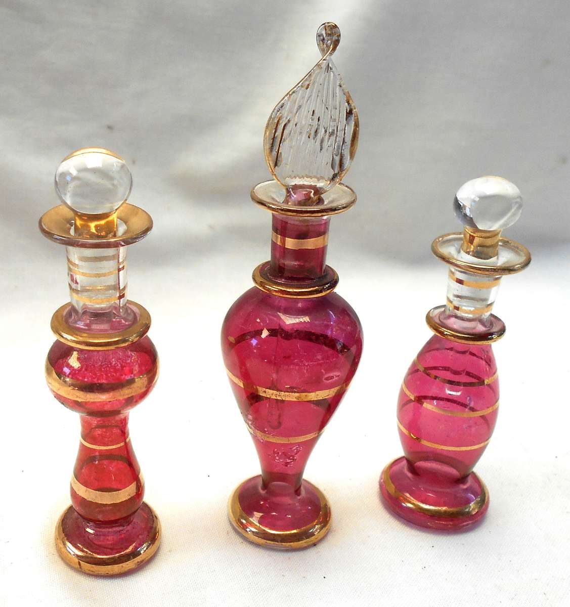 STUNNING three MINIATURE ROSE COLOUR EGYPTIAN GLASS PERFUME BOTTLES WITH DAPPERS