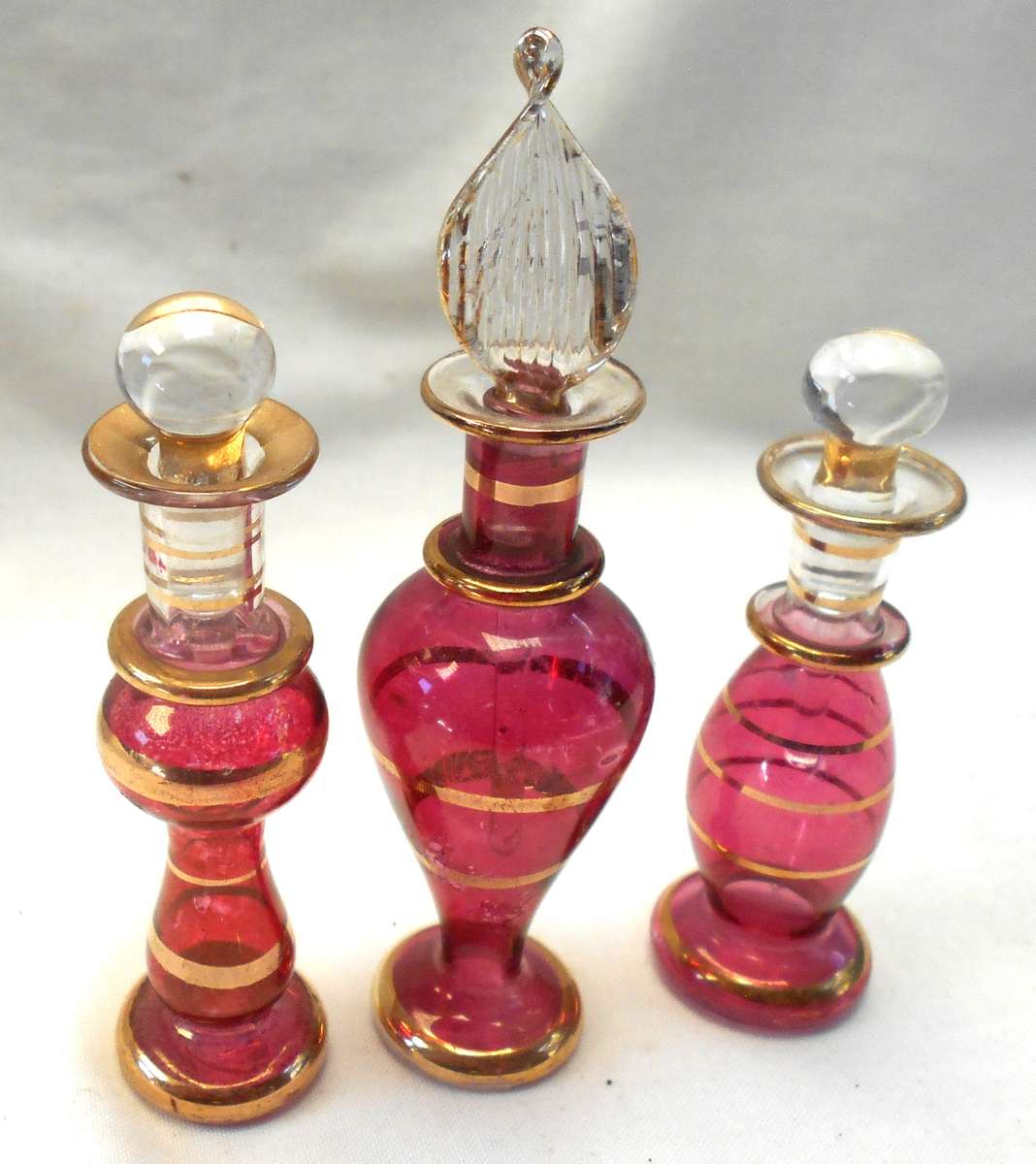 STUNNING three MINIATURE ROSE COLOUR EGYPTIAN GLASS PERFUME BOTTLES WITH DAPPERS