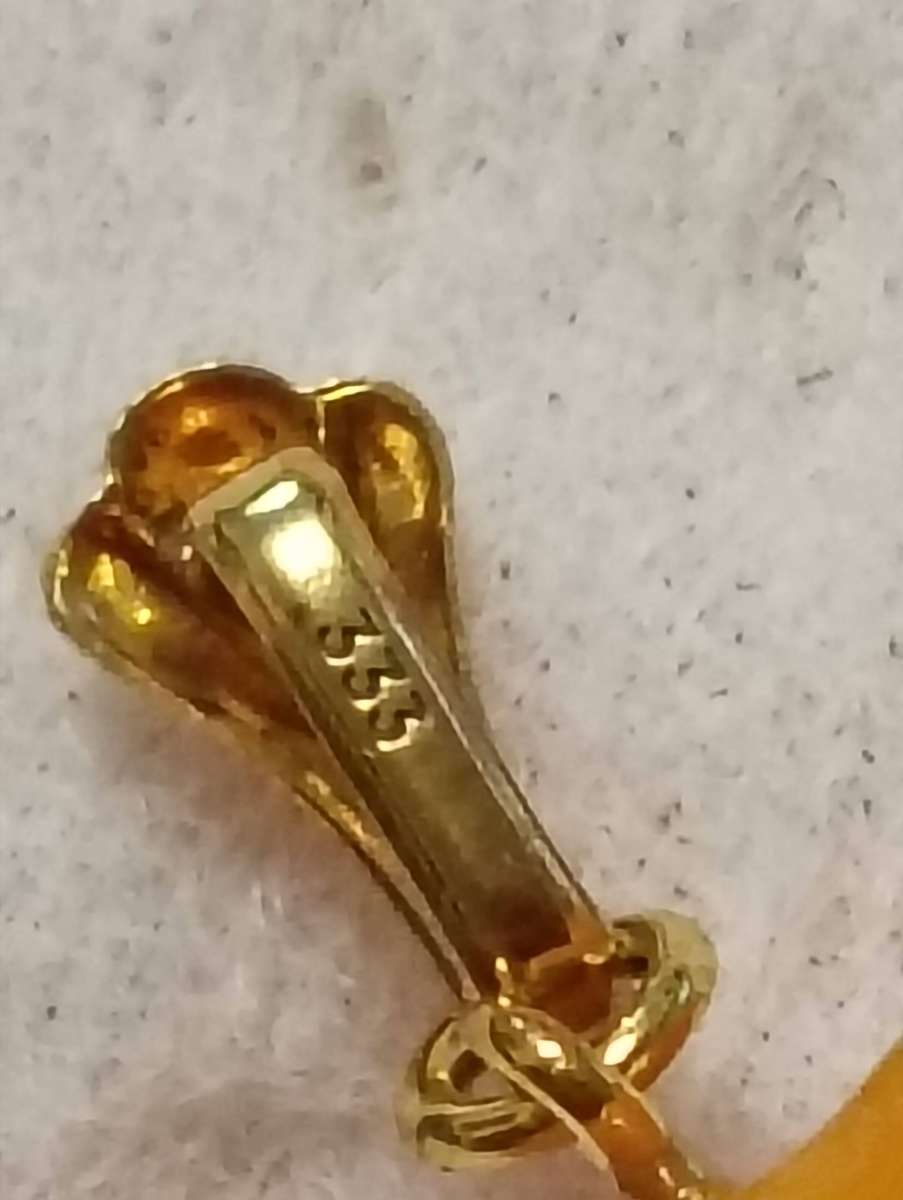 TWO AMBER AND GOLD RHINO PENDANTS.