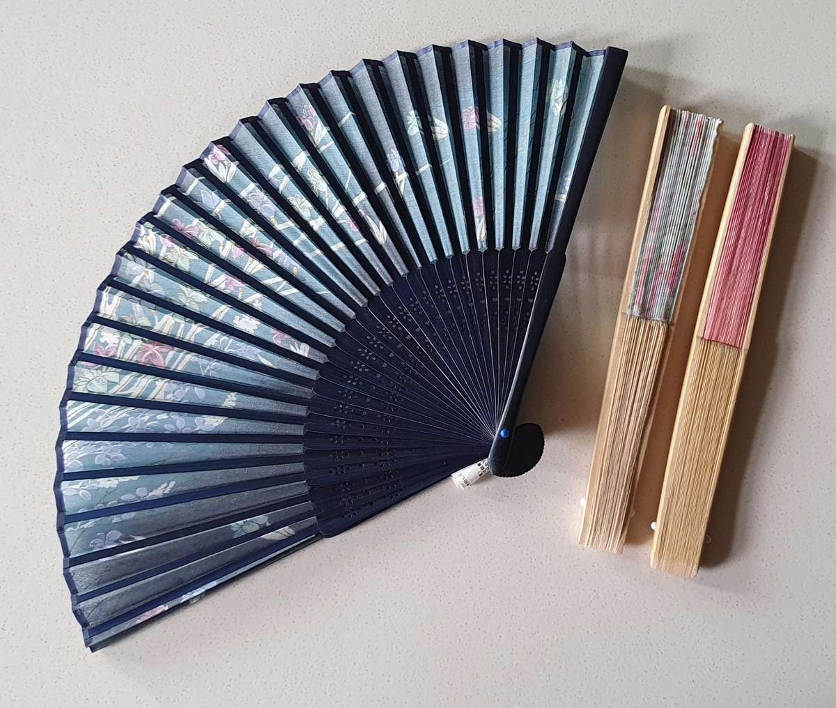 One dark blue colour hand-held folding fan as per photo