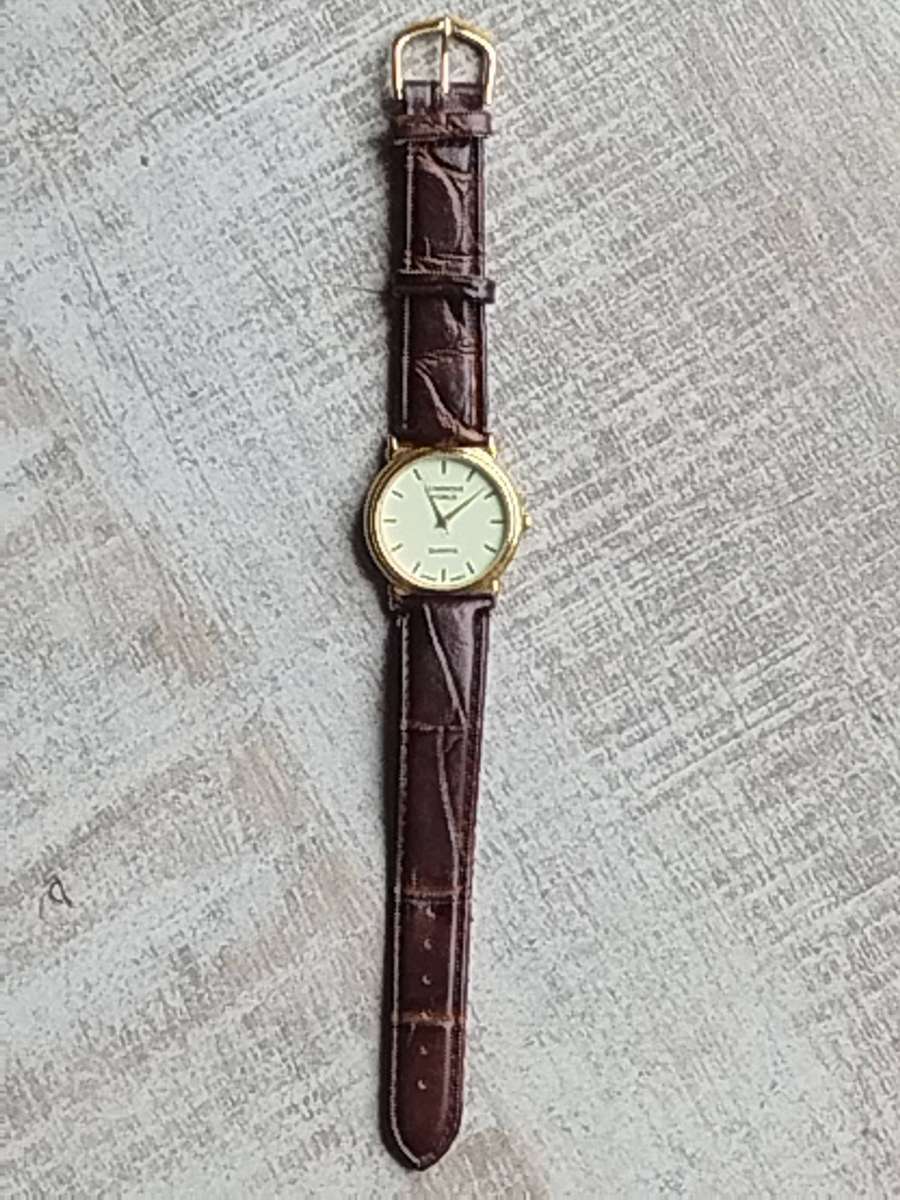 LADIES LUMINOUS WORLD GOLD WATCH WITH STUNNING BROWN LEATHER STRAP IN EXCELLENT WORKING CONDITION