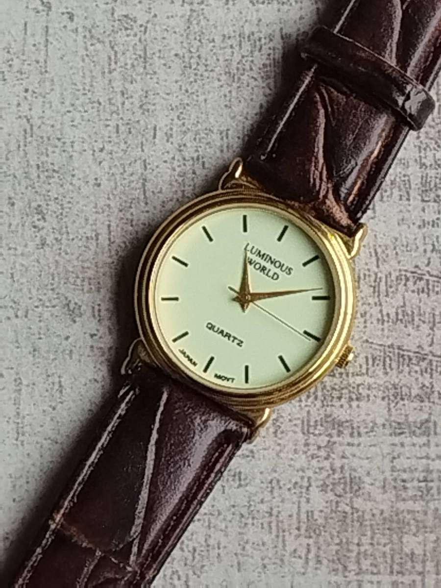 LADIES LUMINOUS WORLD GOLD WATCH WITH STUNNING BROWN LEATHER STRAP IN EXCELLENT WORKING CONDITION