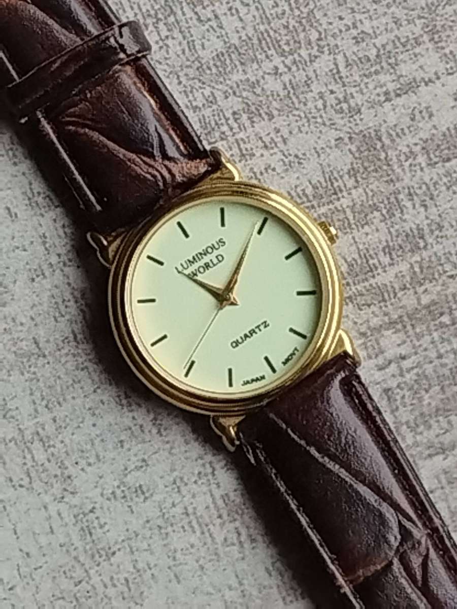 LADIES LUMINOUS WORLD GOLD WATCH WITH STUNNING BROWN LEATHER STRAP IN EXCELLENT WORKING CONDITION