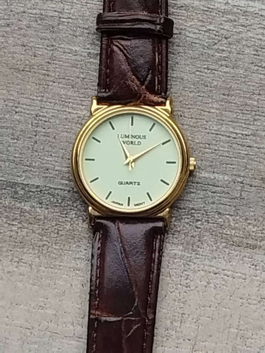 LADIES LUMINOUS WORLD GOLD WATCH WITH STUNNING BROWN LEATHER STRAP IN EXCELLENT WORKING CONDITION