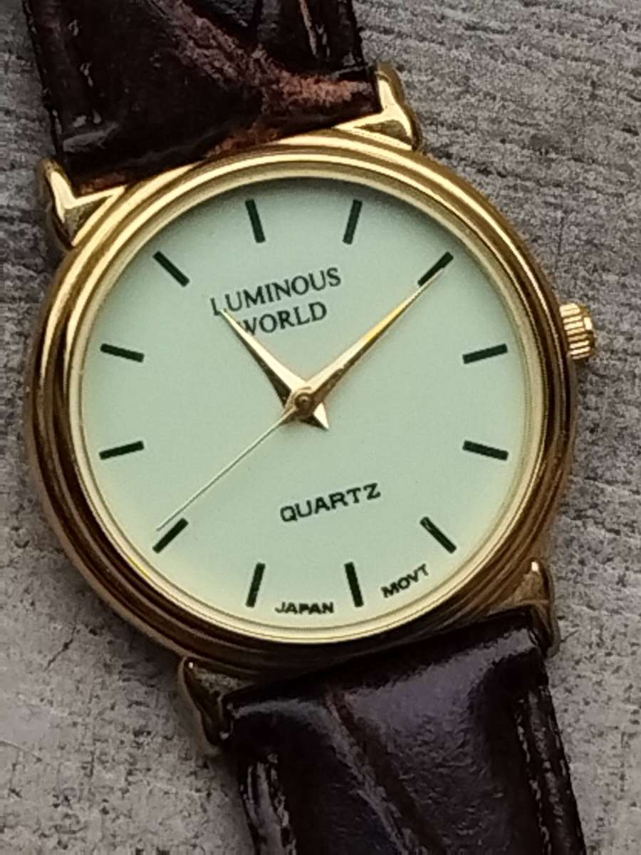 LADIES LUMINOUS WORLD GOLD WATCH WITH STUNNING BROWN LEATHER STRAP IN EXCELLENT WORKING CONDITION