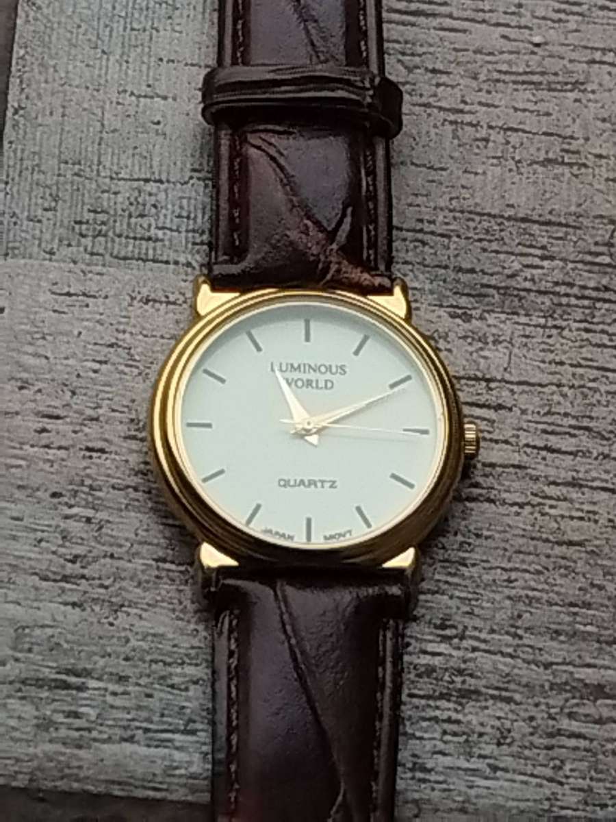 LADIES LUMINOUS WORLD GOLD WATCH WITH STUNNING BROWN LEATHER STRAP IN EXCELLENT WORKING CONDITION