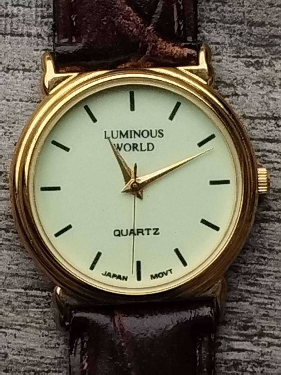 LADIES LUMINOUS WORLD GOLD WATCH WITH STUNNING BROWN LEATHER STRAP IN EXCELLENT WORKING CONDITION