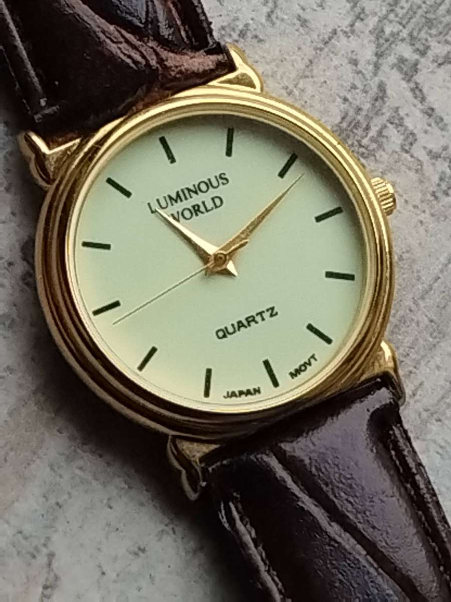 LADIES LUMINOUS WORLD GOLD WATCH WITH STUNNING BROWN LEATHER STRAP IN EXCELLENT WORKING CONDITION