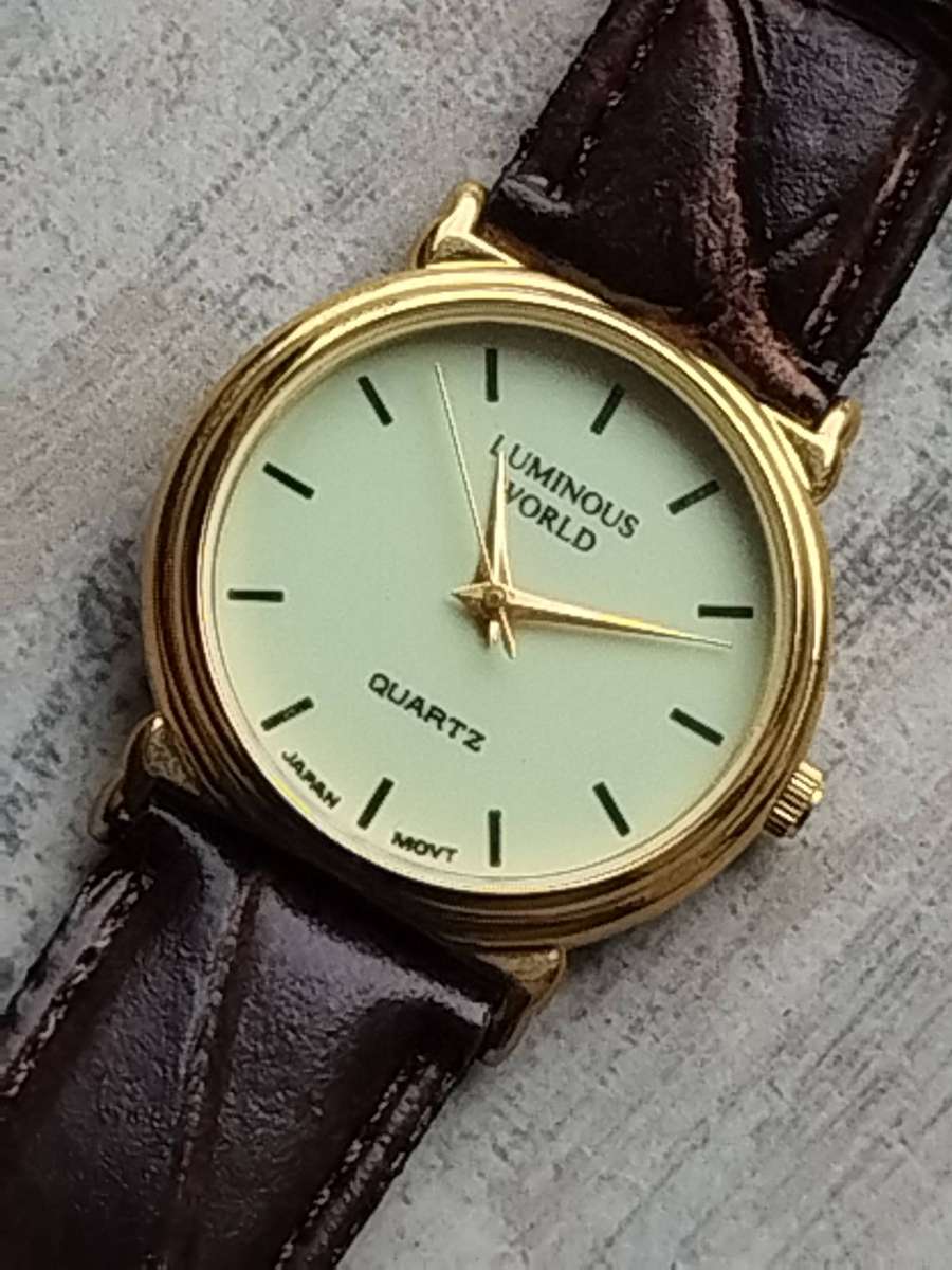 LADIES LUMINOUS WORLD GOLD WATCH WITH STUNNING BROWN LEATHER STRAP IN EXCELLENT WORKING CONDITION