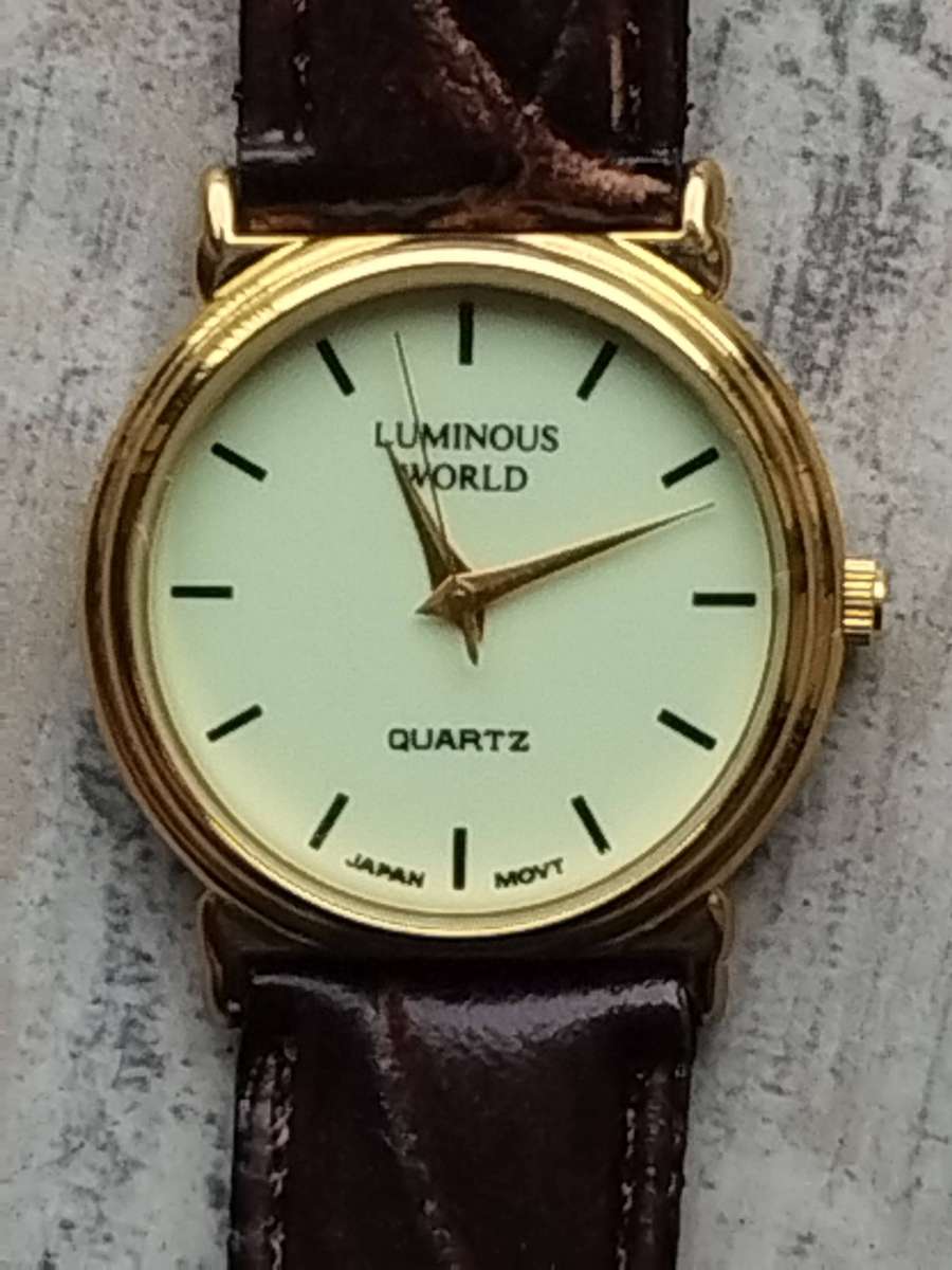 LADIES LUMINOUS WORLD GOLD WATCH WITH STUNNING BROWN LEATHER STRAP IN EXCELLENT WORKING CONDITION