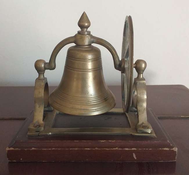 Antique brass bell mounted on wooden plate