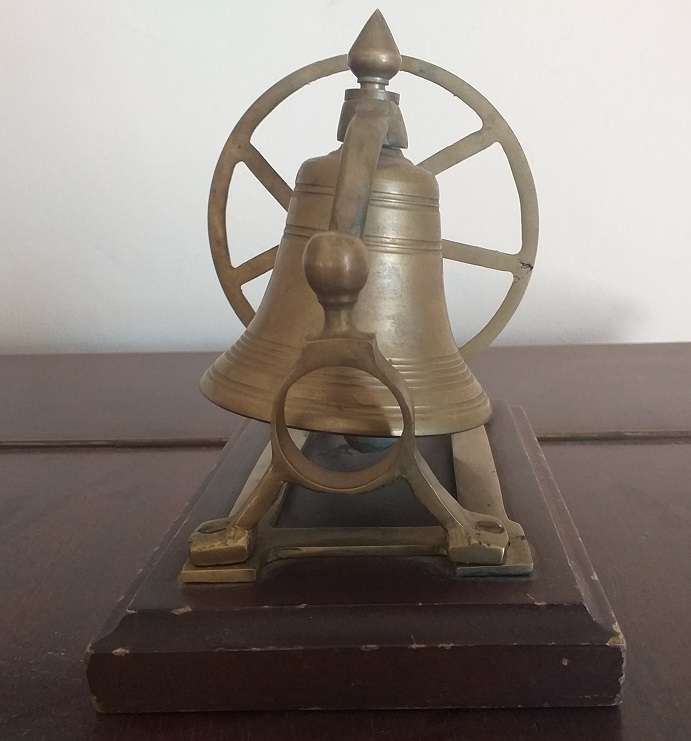 Antique brass bell mounted on wooden plate