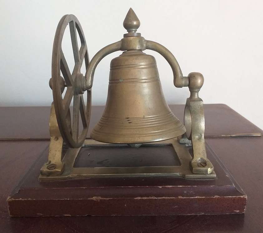 Antique brass bell mounted on wooden plate