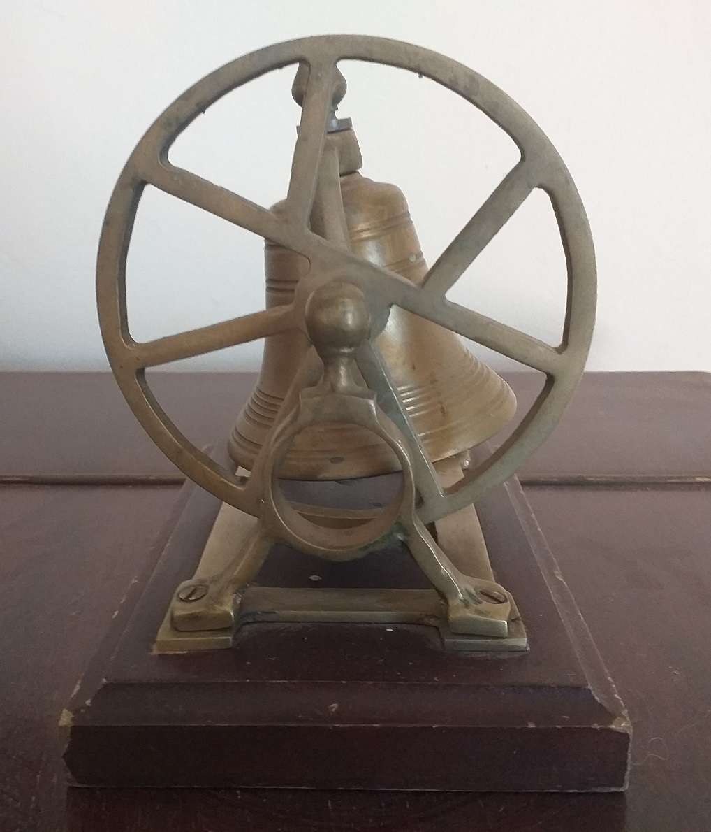 Antique brass bell mounted on wooden plate