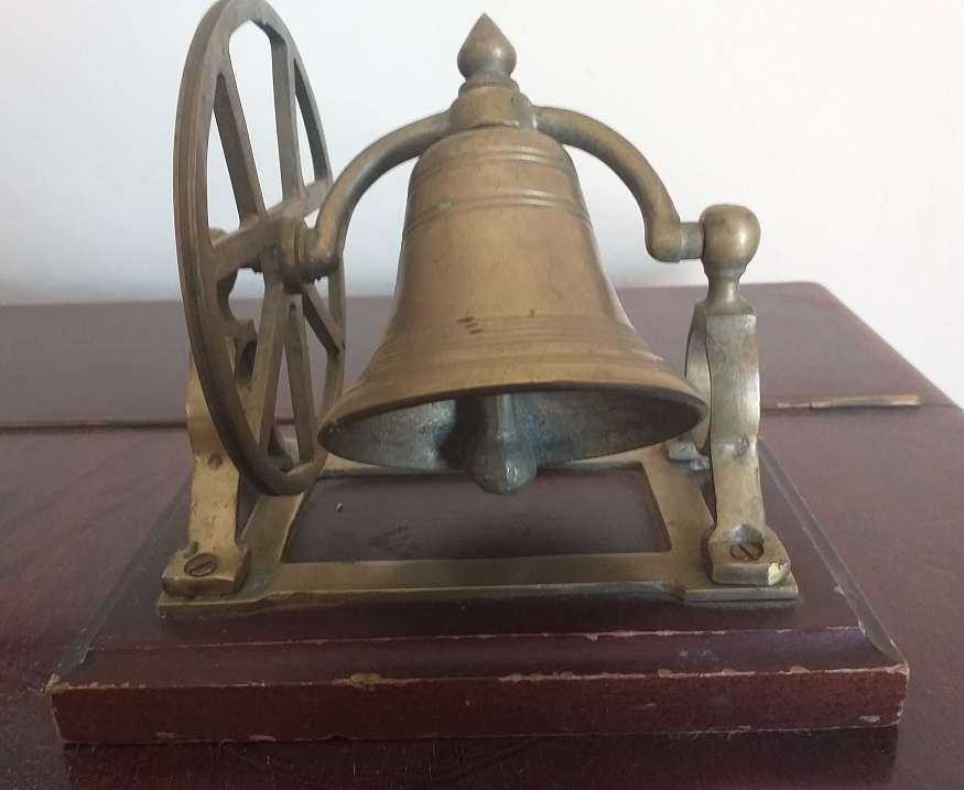 Antique brass bell mounted on wooden plate