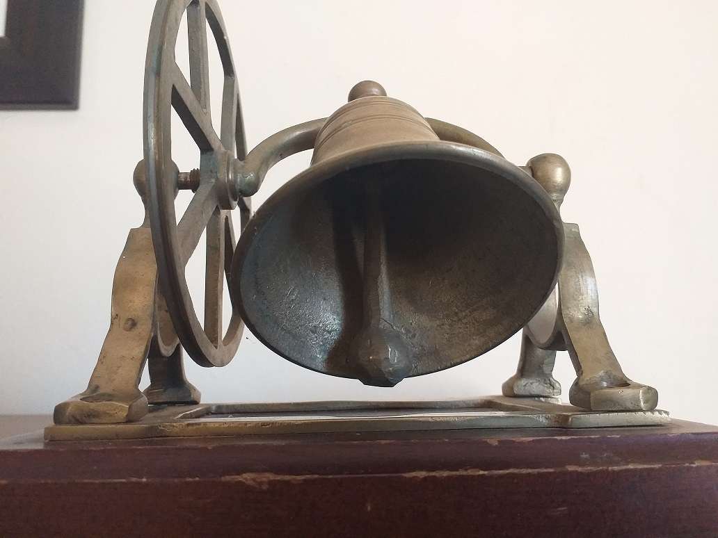 Antique brass bell mounted on wooden plate