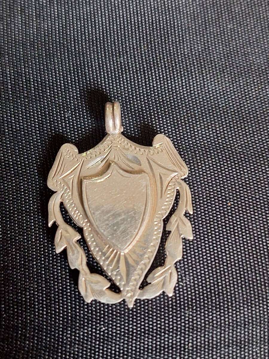 antique sterling silver pendant features a decorative shield design with laurel leaf