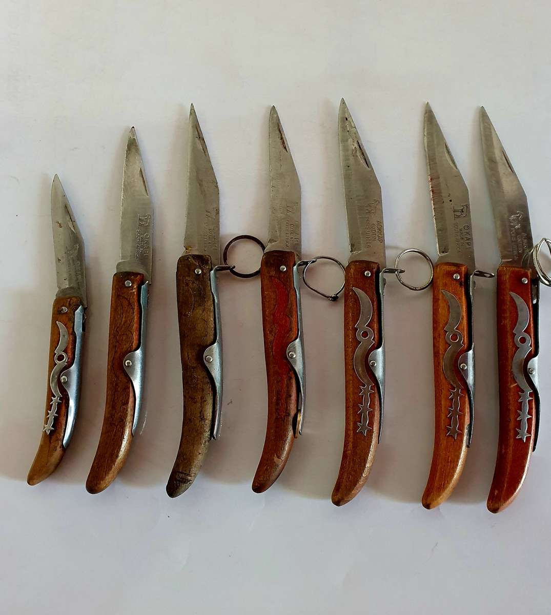 7 X VINTAGE OKAPI FOLDING KNIFES. 5 X 23CM, 1X 21CM, 1 X 18CM.