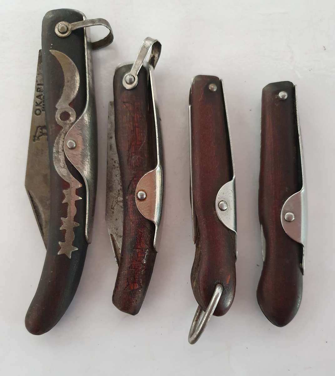 4 X VINTAGE ORIGINAL OKAPI FOLDING KNIFES. INCL. CARBON STEEL. WELL USED.