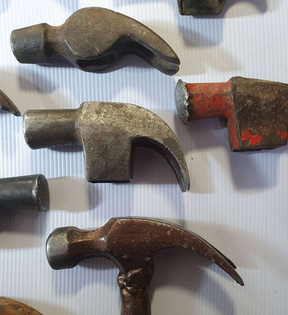12 X ANTIQUE TO VINTAGE CLAW HAMMER HEADS. ONE BID FOR ALL.