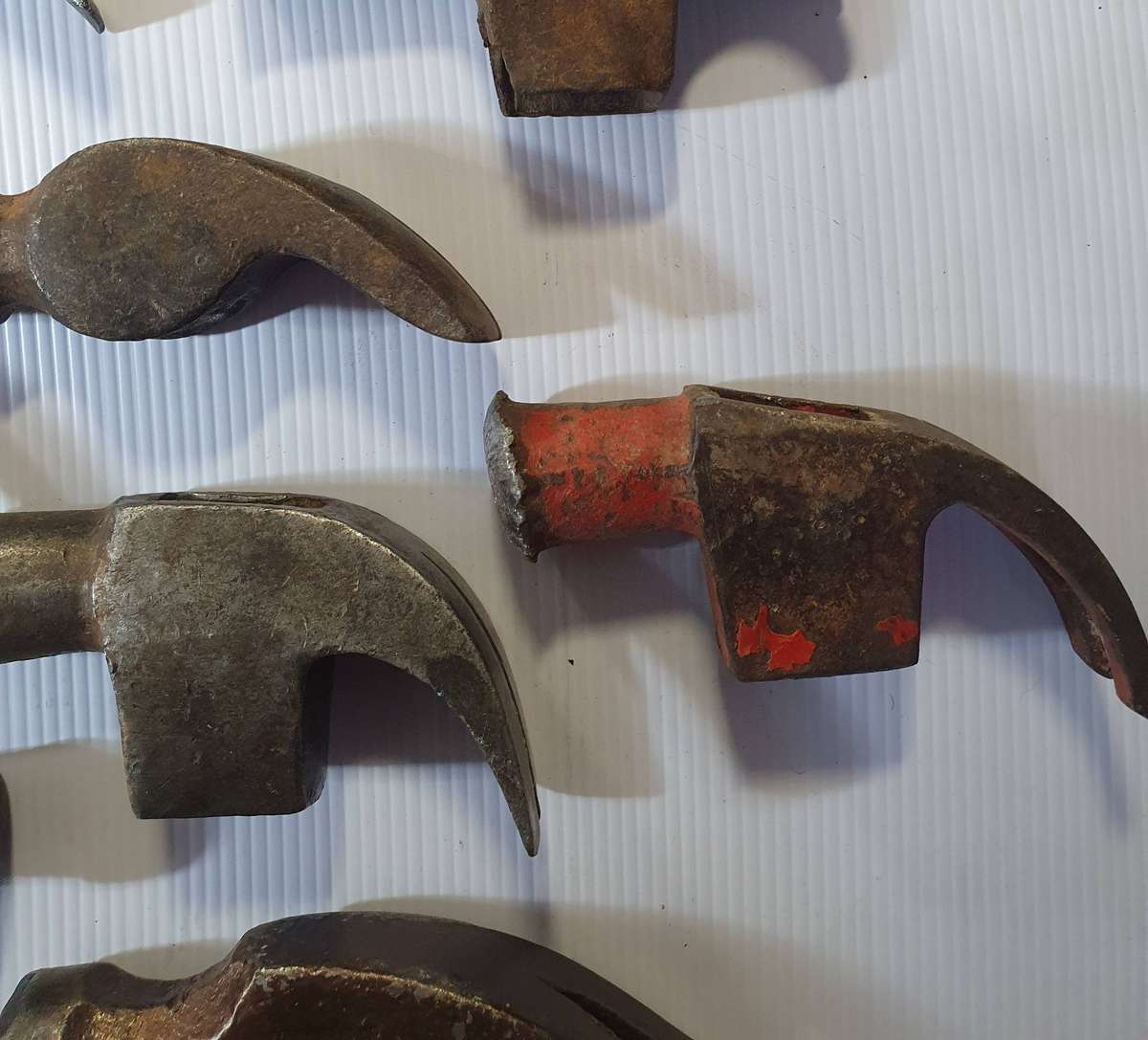 12 X ANTIQUE TO VINTAGE CLAW HAMMER HEADS. ONE BID FOR ALL.