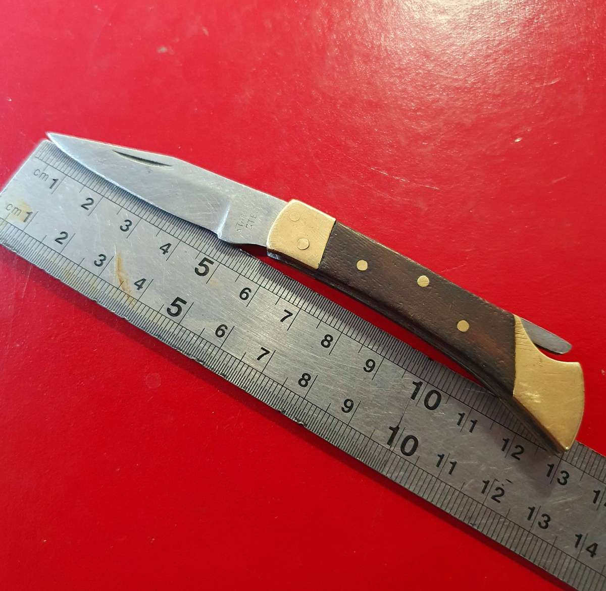 VINTAGE STAINLESS AND BRASS WITH WOOD FOLDING KNIFE.
