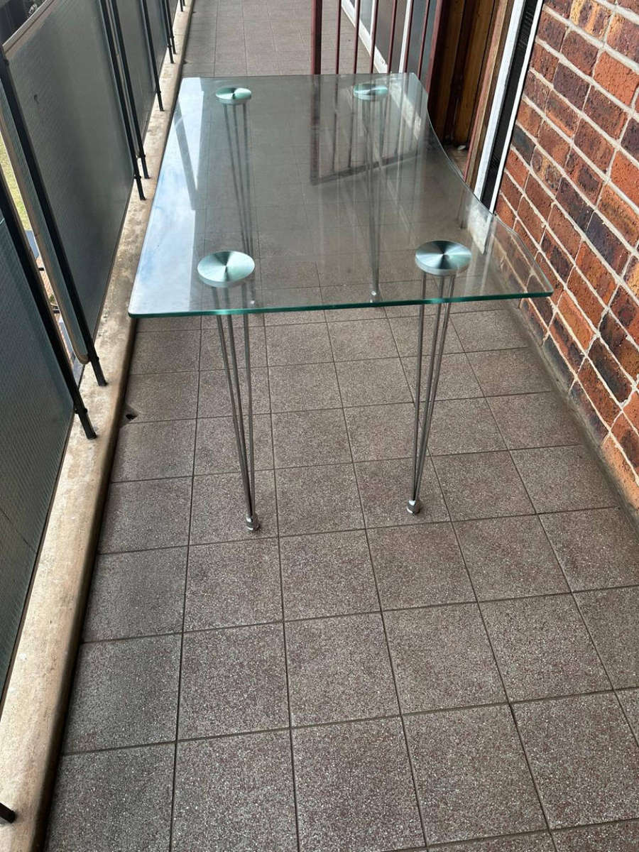 Table with thick glass top and stainless steel legs